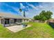 Spacious backyard featuring a screened lanai, hammock, paver patio, fire pit and lush green grass at 3410 5Th W Dr, Palmetto, FL 34221