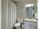 Bathroom featuring a shower with striped curtain, a toilet, and a single sink vanity at 3410 5Th W Dr, Palmetto, FL 34221