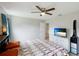 This bedroom has tile floors, a ceiling fan, a TV, and a large window at 3410 5Th W Dr, Palmetto, FL 34221