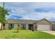Inviting single-story home featuring lush green lawn, an attached garage, and charming turquoise shutters and front door at 3410 5Th W Dr, Palmetto, FL 34221