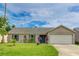 Charming single-story home with a well-manicured lawn, attached garage, and vibrant turquoise shutters and front door at 3410 5Th W Dr, Palmetto, FL 34221