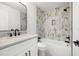 Modern bathroom featuring a shower-over-tub with beautiful tiling and marble countertops at 4146 Brentwood Park Cir, Tampa, FL 33624