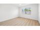 Minimalist bedroom with light wood floors and a large window for plenty of natural light at 4146 Brentwood Park Cir, Tampa, FL 33624