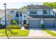 Two-story townhouse with a well-manicured lawn, gray exterior and gray garage doors at 4146 Brentwood Park Cir, Tampa, FL 33624