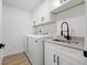 Functional laundry room with modern appliances, sink, cabinet storage, and neutral decor at 4146 Brentwood Park Cir, Tampa, FL 33624