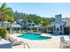 Community pool with lounge chairs, tables, and umbrellas, surrounded by well-manicured landscaping and a pool house at 4146 Brentwood Park Cir, Tampa, FL 33624