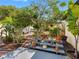 Lush backyard features multi-level patios surrounded by a variety of tropical plants and trees at 4532 W Idlewild Ave, Tampa, FL 33614