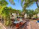 Charming backyard oasis with brick pathways, wood deck with seating, and lush tropical foliage at 4532 W Idlewild Ave, Tampa, FL 33614