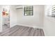 Bedroom featuring gray wood-look floors, mini-split AC, and natural light from a window at 4532 W Idlewild Ave, Tampa, FL 33614