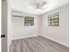 Bedroom featuring gray wood-look floors, a ceiling fan, and natural light from two windows at 4532 W Idlewild Ave, Tampa, FL 33614