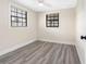 Bedroom featuring gray wood-look floors, a ceiling fan, and natural light from two windows at 4532 W Idlewild Ave, Tampa, FL 33614