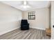 Bedroom with gray wood-look floors, a large chair, and natural light from a window at 4532 W Idlewild Ave, Tampa, FL 33614