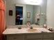 Bathroom with a large mirror over the vanity, framed art, and patterned towels at 4558 Blossom Blvd # D, Zephyrhills, FL 33542