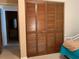 Bedroom closet featuring folding wooden doors and a glimpse into the bedroom and ensuite bath at 4558 Blossom Blvd # D, Zephyrhills, FL 33542