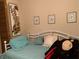 Charming bedroom with a white metal bed frame, decorative pillows, and framed wall art at 4558 Blossom Blvd # D, Zephyrhills, FL 33542