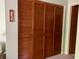 Bedroom closet with full length, louvered doors, wooden knobs and adjacent hallway at 4558 Blossom Blvd # D, Zephyrhills, FL 33542