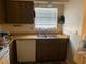Functional kitchen featuring a double sink, wood cabinets, and a window with natural light at 4558 Blossom Blvd # D, Zephyrhills, FL 33542