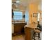 Simple kitchen with wood cabinets and breakfast bar with stools at 4558 Blossom Blvd # D, Zephyrhills, FL 33542