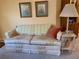 A floral sofa is decorated with a throw blanket and pillow in this simple living room at 4558 Blossom Blvd # D, Zephyrhills, FL 33542