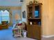 Cozy living room features a floral sofa, lamp, and wooden cabinet with glass doors at 4558 Blossom Blvd # D, Zephyrhills, FL 33542