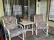 Cozy outdoor patio seating area with floral cushions and a small white table at 4558 Blossom Blvd # D, Zephyrhills, FL 33542