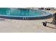 Community pool with a six-foot depth marker, surrounded by concrete decking and lounge chairs at 4558 Blossom Blvd # D, Zephyrhills, FL 33542