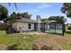 Exterior shot of a house showcasing the screened in pool area from the backyard, grass and some trees at 4715 Kemble Ct, Tampa, FL 33624