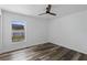 Bedroom with modern ceiling fan, wood-look floors, and large window view to backyard at 4715 Kemble Ct, Tampa, FL 33624