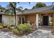 Up close front porch with a landscaped walkway leading to the covered entrance with black door and modern planters at 4715 Kemble Ct, Tampa, FL 33624