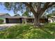 Charming single-story home featuring a well-maintained lawn and mature landscaping with a beautiful shade tree at 4715 Kemble Ct, Tampa, FL 33624