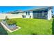 Expansive, manicured backyard with lush lawn, garden beds, and white vinyl fence at 5415 Los Robles Ct, Palmetto, FL 34221