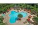 An overhead shot reveals a resort-style pool with ample seating, umbrellas, and lush tropical landscaping at 5415 Los Robles Ct, Palmetto, FL 34221
