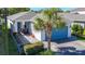 Charming single-story home with a blue garage door, paver driveway and walkway, and lush tropical landscaping at 5415 Los Robles Ct, Palmetto, FL 34221