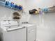 Clean laundry room with modern washer, dryer, and practical shelving for storage at 5415 Los Robles Ct, Palmetto, FL 34221