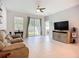 Bright living room featuring neutral-toned tile floors, a ceiling fan, and sliding glass doors to the lanai at 5415 Los Robles Ct, Palmetto, FL 34221