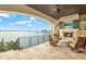 Outdoor balcony featuring travertine flooring, a fireplace, and a stunning view of the ocean at 5630 Bayview Dr, Seminole, FL 33772