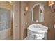 Elegant bathroom featuring a marble vanity, decorative mirror, and walk-in shower at 5630 Bayview Dr, Seminole, FL 33772