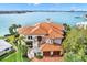 Stunning waterfront home with a vibrant terracotta roof and lush landscaping, offering picturesque views at 5630 Bayview Dr, Seminole, FL 33772