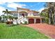 Elegant two-story home with a charming brick driveway and manicured lawn at 5630 Bayview Dr, Seminole, FL 33772