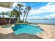 Backyard pool with turquoise water and palm trees overlooking the bay at 5630 Bayview Dr, Seminole, FL 33772