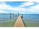 Tranquil waterfront view of a private boat dock extending into the calm, clear waters at 5630 Bayview Dr, Seminole, FL 33772