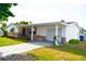 Charming single-story home with white siding, stone accents, and a well-manicured lawn at 7435 Hollyridge Dr, New Port Richey, FL 34653