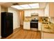 Modern kitchen with white cabinets, granite countertops, stainless steel appliances, and wood floors at 7435 Hollyridge Dr, New Port Richey, FL 34653