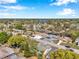Expansive aerial view of a residential neighborhood featuring tree-lined streets and a lake in the distance at 7824 Blackstone Dr, Port Richey, FL 34668