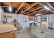 Unfinished basement area with exposed wood beams, utilities, and potential workshop space at 7824 Blackstone Dr, Port Richey, FL 34668