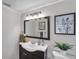 Bathroom featuring a dark vanity cabinet, modern sink, decorative mirror, and stylish decor at 7824 Blackstone Dr, Port Richey, FL 34668