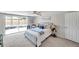 Bright main bedroom with tufted headboard, ceiling fan, neutral paint and sliding glass door to backyard at 7824 Blackstone Dr, Port Richey, FL 34668
