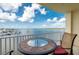 Balcony view showing a table and a view of the bay with boats, blue skies and clouds at 8800 Bay Pines Blvd # 318, St Petersburg, FL 33709