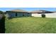 Backyard with lush green grass, rear house view, and vinyl fence at 9736 Sage Creek Dr, Ruskin, FL 33573