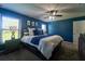 Blue bedroom featuring a king size bed, two windows and an attractive ceiling fan at 9736 Sage Creek Dr, Ruskin, FL 33573